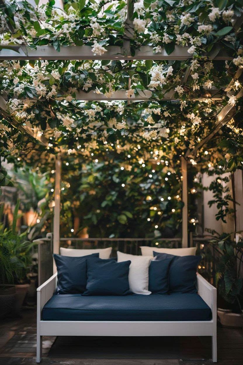 An overhead pergola trellis on a balcony with a narrow daybed underneath and leafy climbing vines above