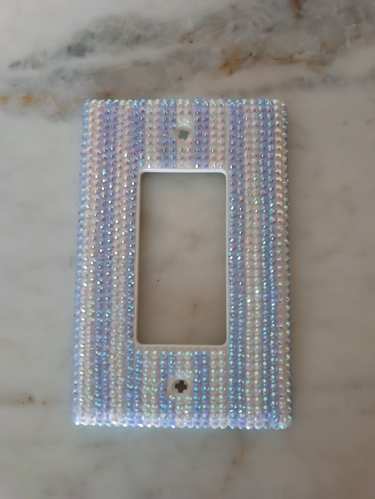 Rhinestones and gems sorted by color and size for a switch plate project